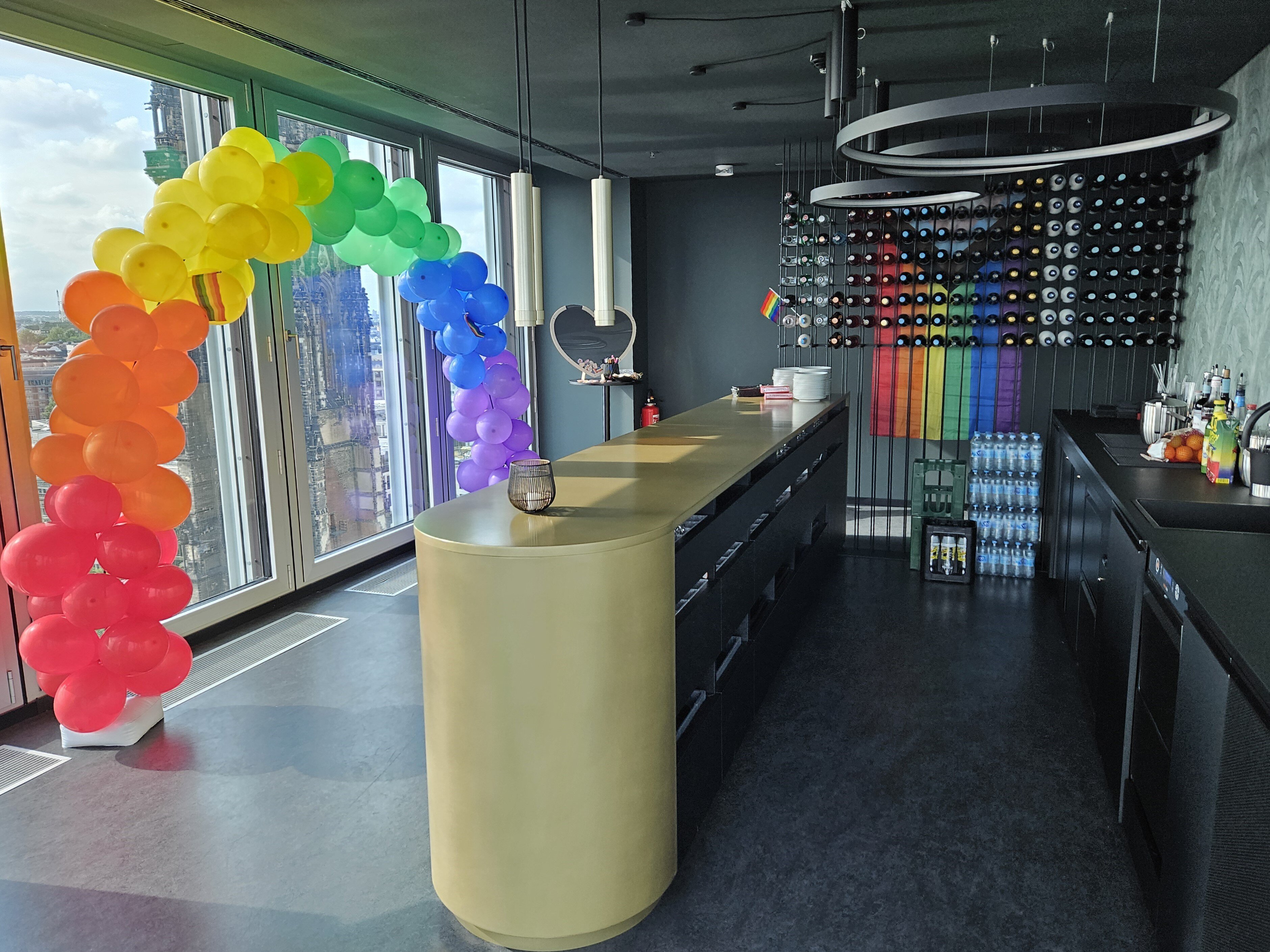 Eine geschmückte Bar mit einem Regenbogen aus Luftballons. 
