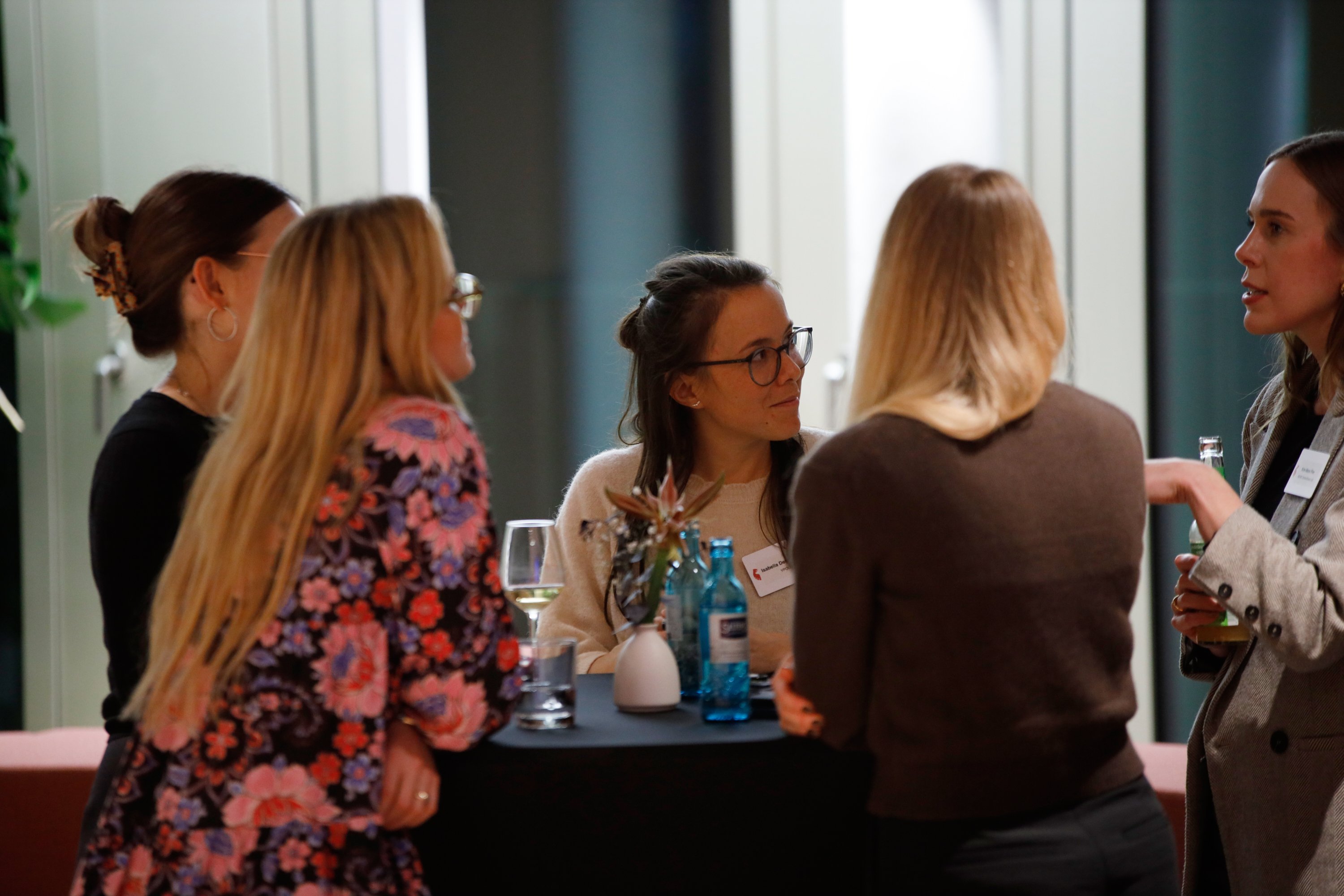 Fünf Frauen unterhalten sich angeregt um einen Stehtisch