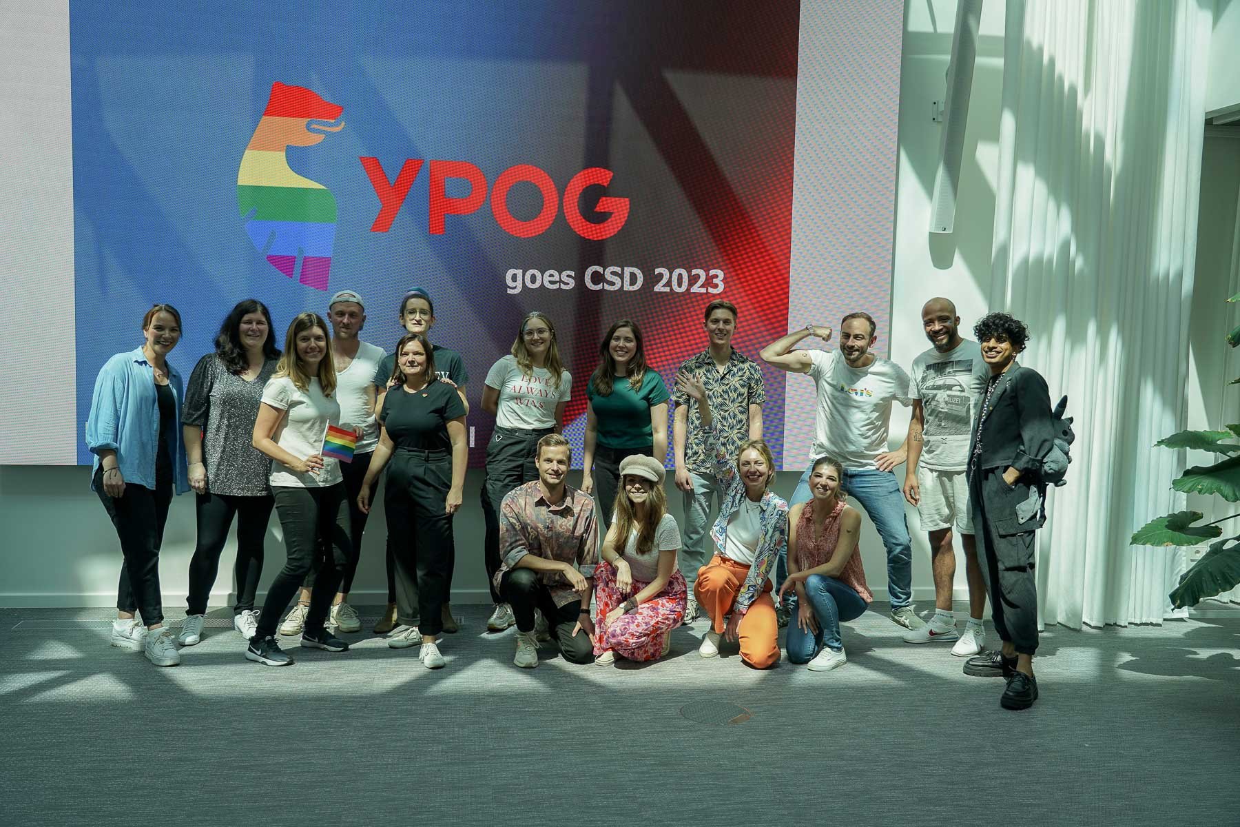 A group of people posing in front of a large sign reading “YPOG goes CSD 2023”.