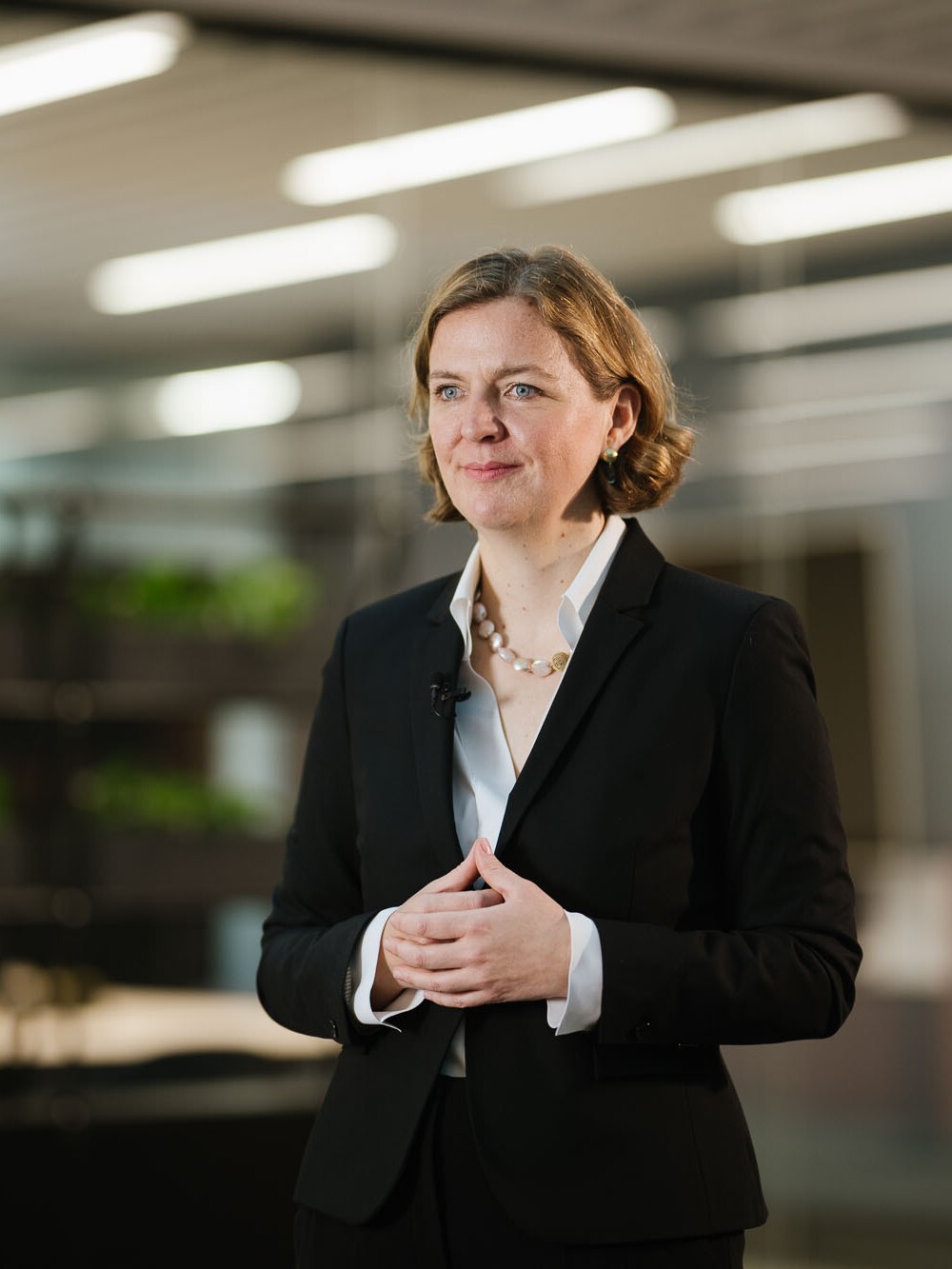 Eine Frau steht und wartet aug ihren Einsatz etwas zu erklären.