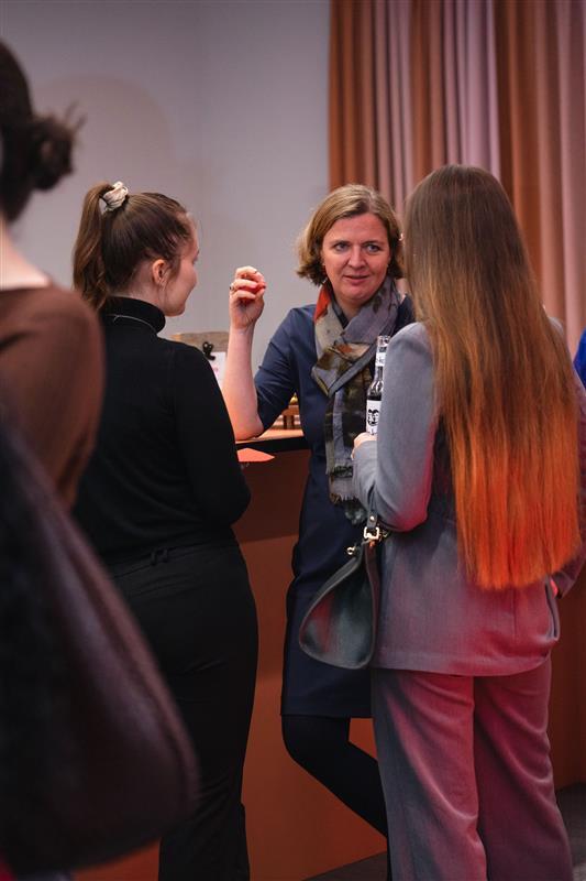 Drei Frauen stehen an einem Tresen und unterhalten sich